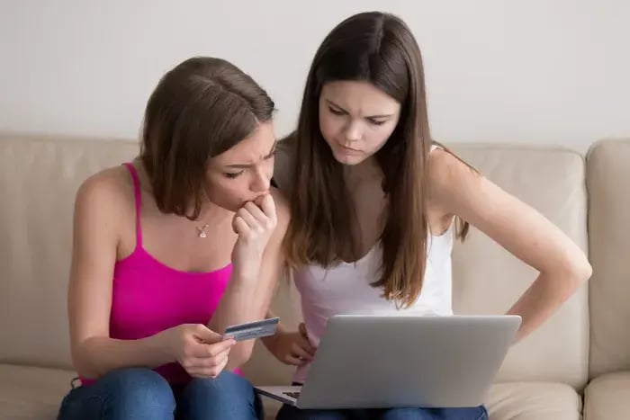 Customers confirming eyewear purchase on laptop after selecting frames with virtual try-on.