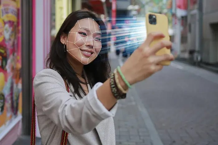 Woman using smartphone face shape detection technology for personalized virtual eyewear try-on.