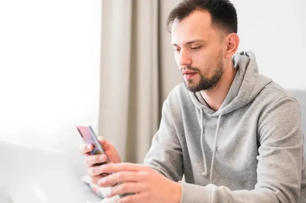 homme-regardent-son-telephone