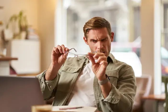 Man reviewing eyeglass frames before completing an online order.
