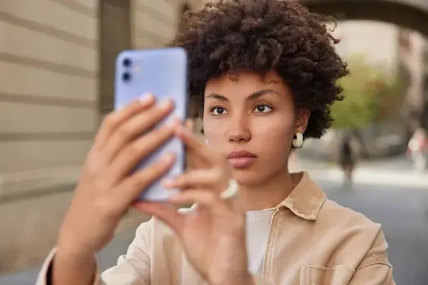 une-femme-prend-une-photo-d-elle-meme-avec-un-smartphone-pour-le-partager-sur-les-reseaux-sociaux-regarde-attentivement-la-camera-profite-du-temps-de-recreation-en-ville-1
